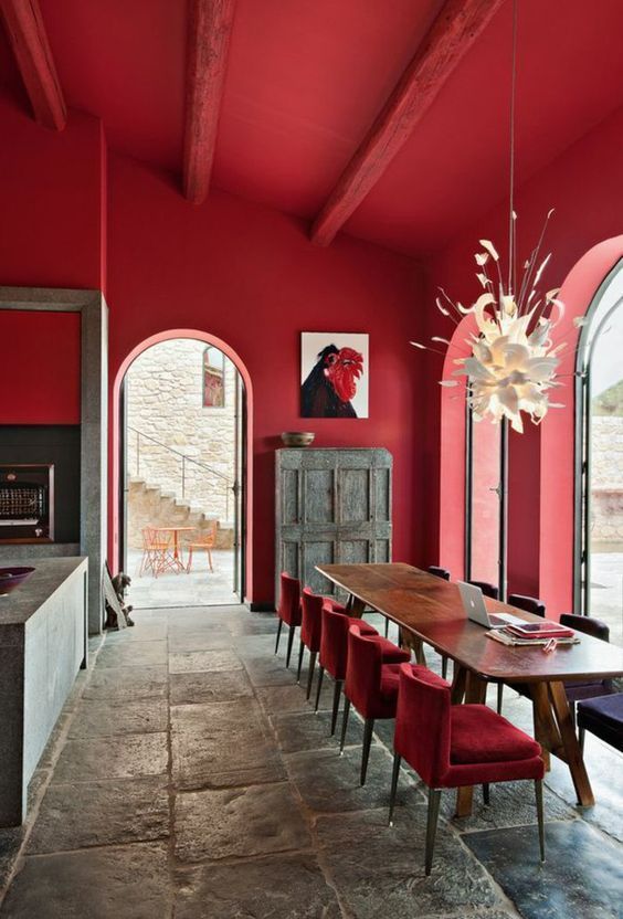 a dining room with red walls and chairs