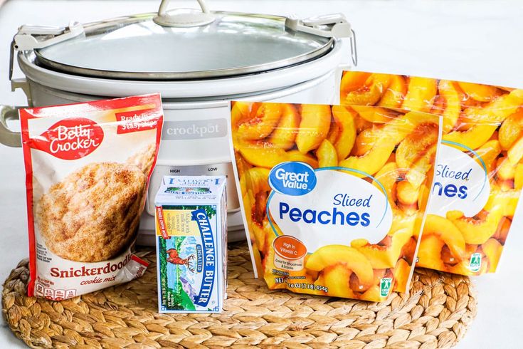 some food is sitting in front of a crock pot and two bags of peaches