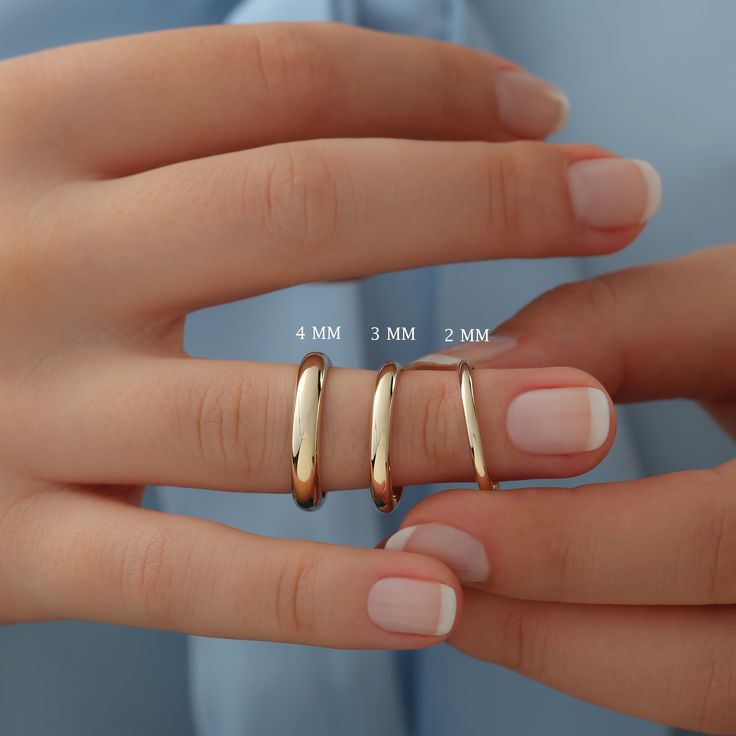 a woman's hand with three gold rings on her fingers, and the measurements for each ring