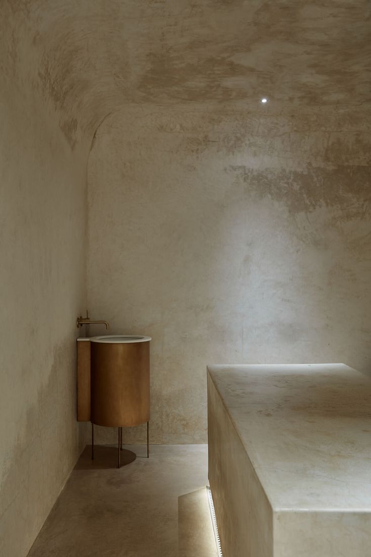 an empty room with a table and two stools in the corner next to it