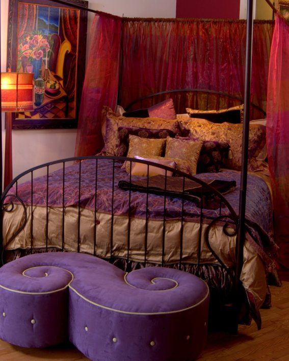 a bed with purple and gold decor in a bedroom