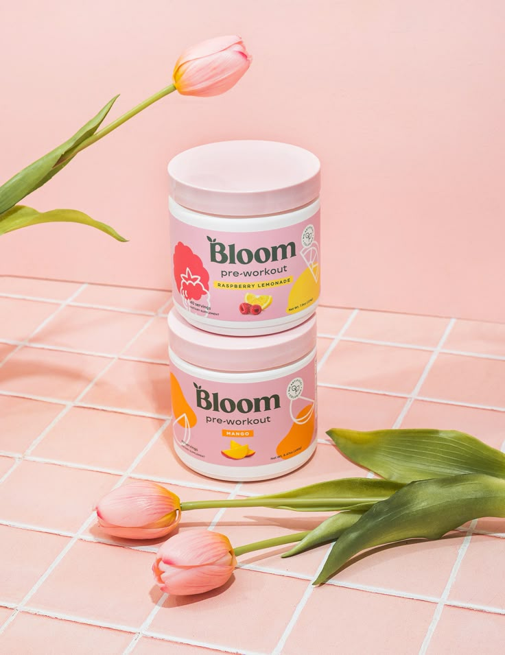 two tubs of bloom are sitting on a pink tile floor next to tulips