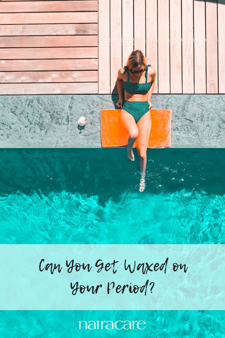 a woman in a bathing suit sitting on an orange floater with the words can you get unwanted on your period?