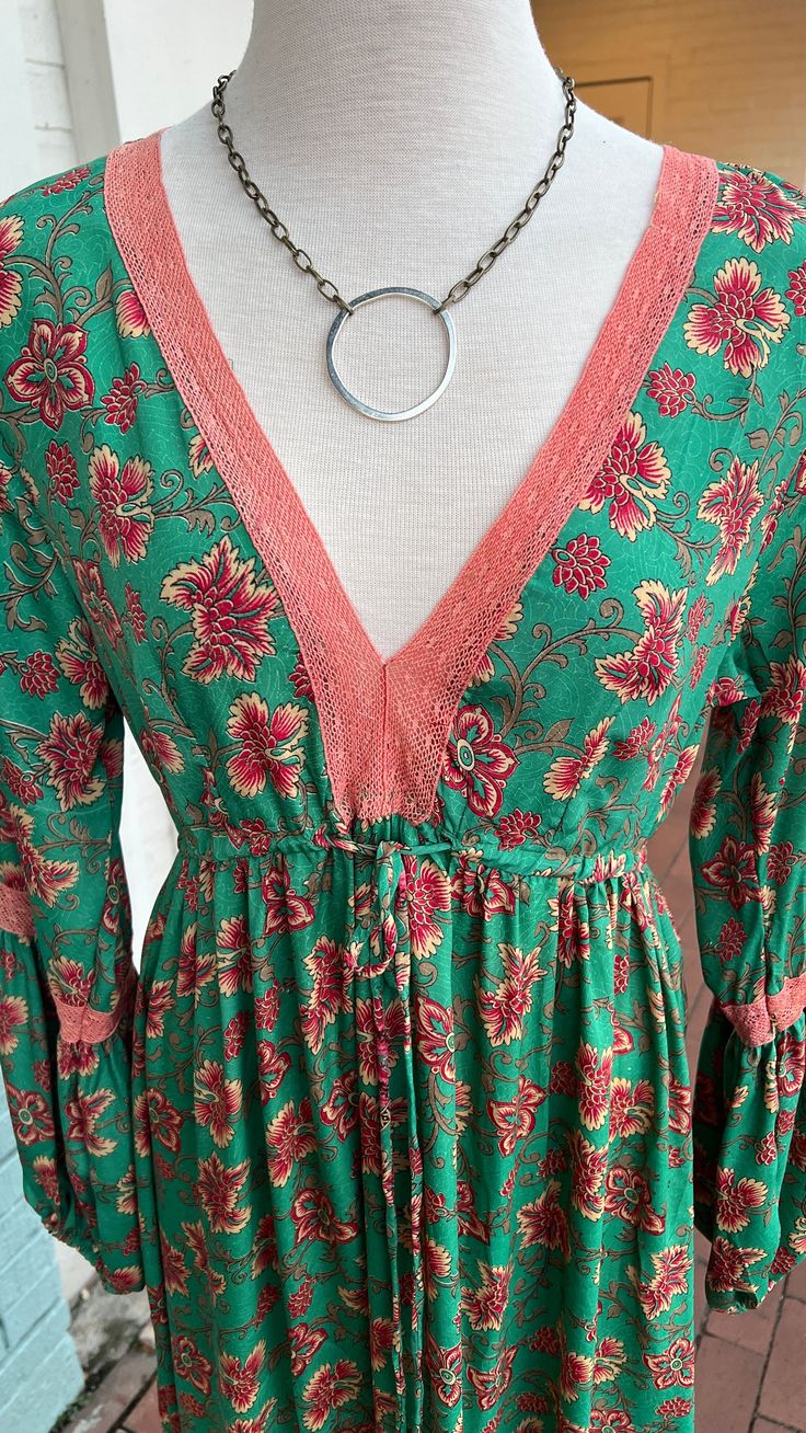 Embrace your inner boho princess this holiday season with our Holiday in the Hills Green Maxi Dress! Made with luxurious silky fabric and delicate lace trim, this dress will make you feel like royalty. The drawstring waistband adds a touch of whimsy and allows for the perfect fit. Don't miss out on this must-have dress for your next adventure! PLEASE READ MEASUREMENTS This dress is one size only in very limited quantities - no restocks. You can make the waist smaller, but no larger than below measurements. No stretch to fabric. 100% POLY - Made in India Measurements taken flat Bust arm 40” Drawstring waist fully extended 19” Upper Arm sleeve width 7” Arm width at contrast lace 6” Shoulder to Hem 53” Elastic puff cuff Dress does not fit Deborah who is a size XL. If we still have stock left Flowy V-neck Boho Dress With Lace Trim, Bohemian Long Sleeve Dress With Lace Trim, Maxi Length Boho Dress With Lace Trim, Flowy Rayon Dress With Lace Trim, Bohemian Long Sleeve Maxi Dress With Lace Trim, Green Bohemian Holiday Dress, Flowy Boho Dress With Lace Trim For Festival, Bohemian Boho Dress With Lace Trim, Festive Bohemian V-neck Maxi Dress