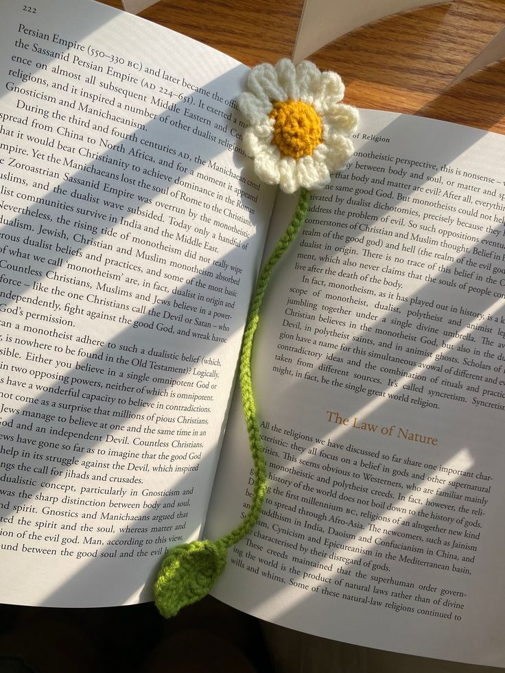 a crocheted flower on top of an open book