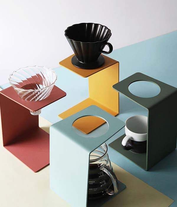 an assortment of different colored boxes with cups and saucers on them, sitting on top of each other