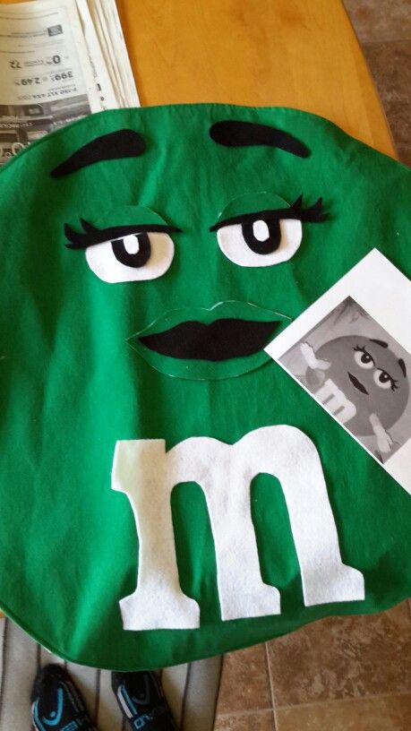 a green bag with the letter m on it, and a face drawn in white