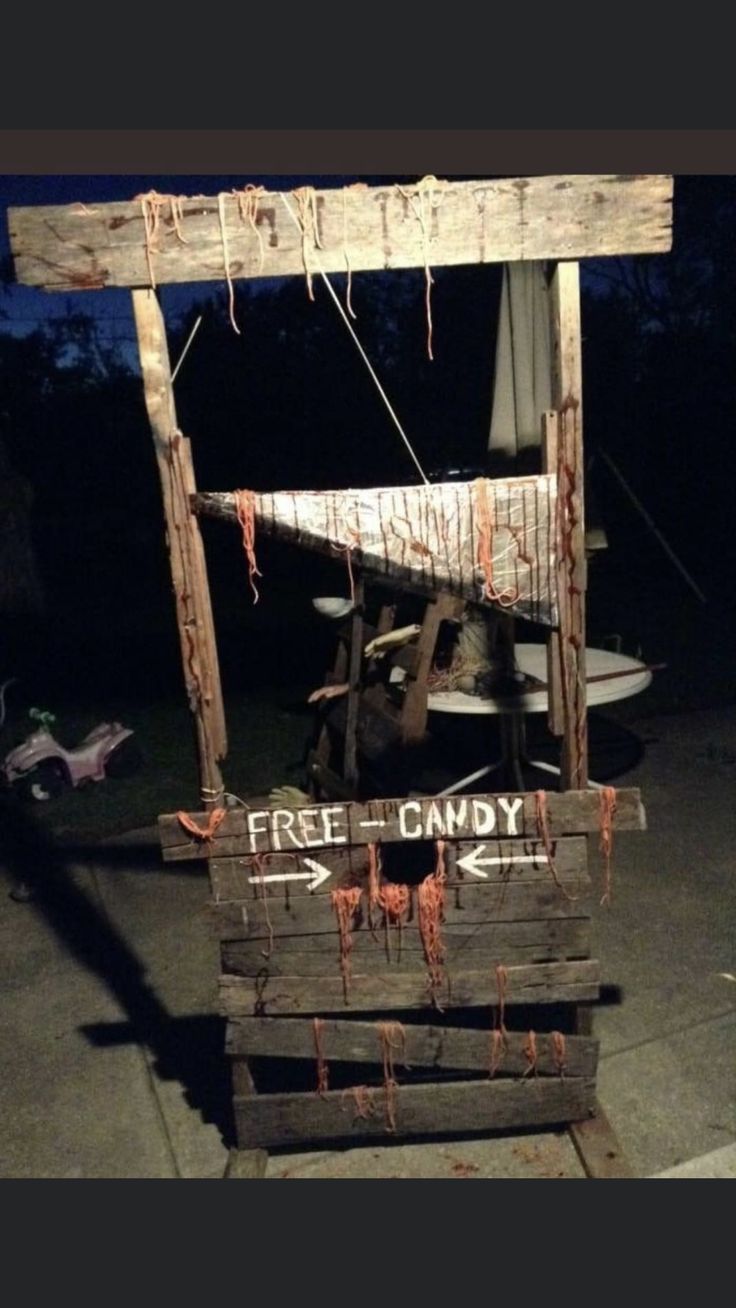 a wooden sign that says free candy hanging from it's side with blood dripping all over the sides