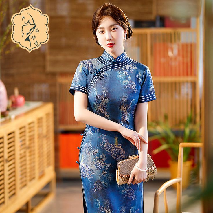 Step into timeless elegance with this stunning blue Qipao / Cheongsam, perfect for any special occasion. This dress features an intricate pattern of peony flowers. The high mandarin collar and short sleeves add a touch of traditional charm, while the white piping and diagonal closure with frog buttons enhance its classic appeal. Ideal for weddings, tea ceremonies, or any event where elegance is key. Size Guide: Size Bust(cm) Waist(cm) Hip(cm) Shoulder(cm) Length(cm) M 86 70 90 37 125 L 90 74 94 Elegant Floral Print Cheongsam With Stand Collar, Elegant Fitted Blue Cheongsam, Elegant Blue Cheongsam For Spring, Blue Fitted Cheongsam With Stand Collar, Traditional Short Sleeve Fitted Cheongsam, Elegant Blue Ao Dai For Formal Occasions, Fitted Floral Print Cheongsam With Short Sleeves, Fitted Short Sleeve Floral Cheongsam, Spring Formal Short Sleeve Cheongsam