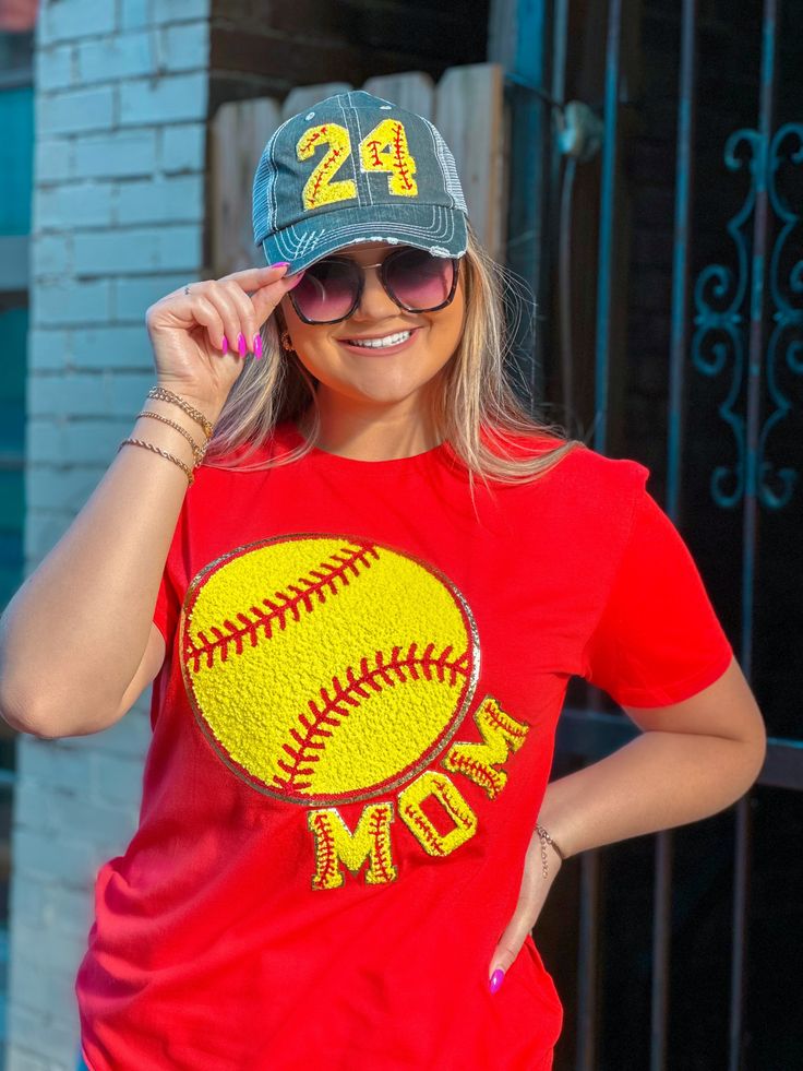 a woman wearing a baseball hat and red t - shirt with the number 24 on it