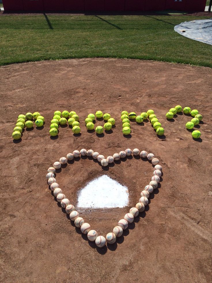 a heart made out of tennis balls in the shape of a happy sign on top of a baseball field