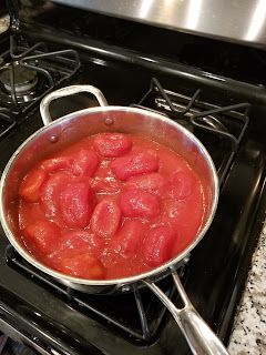 a pan filled with meat sitting on top of a stove next to a burner