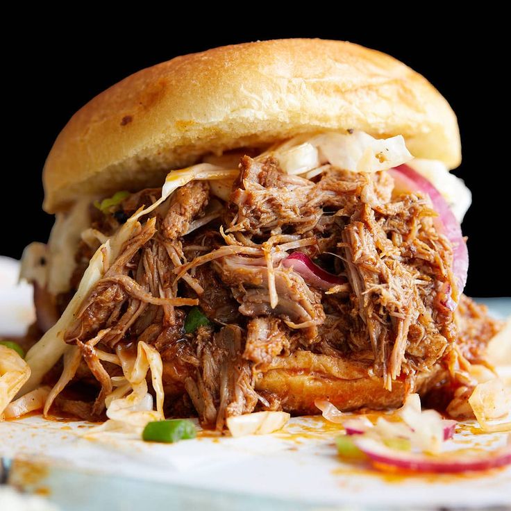 a pulled pork sandwich with cole slaw on a plate