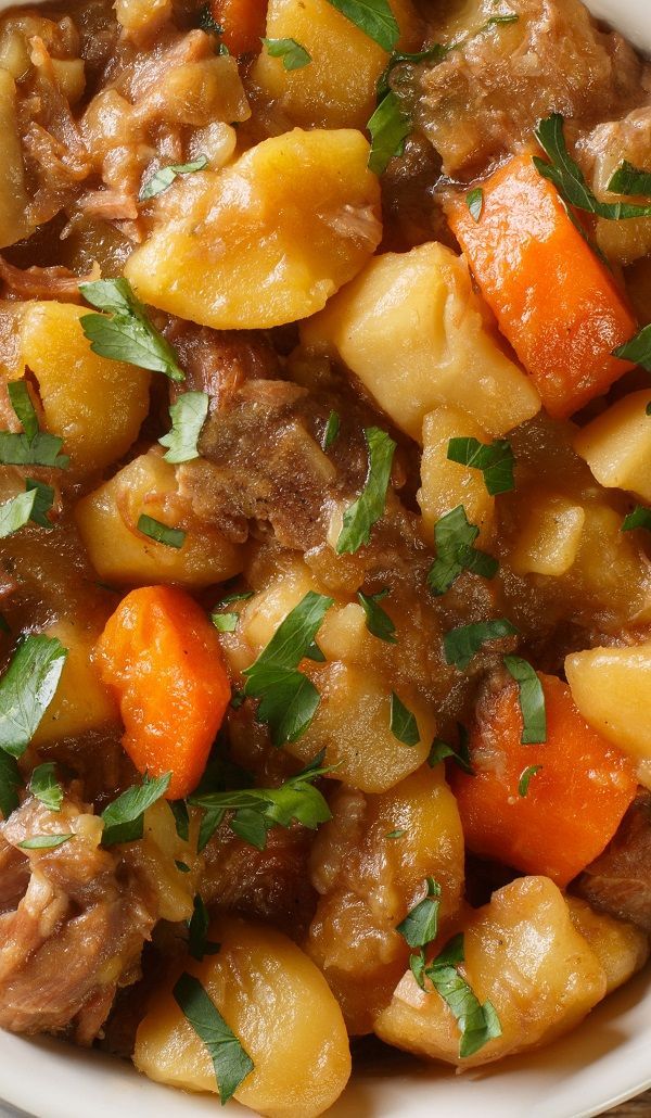 a white bowl filled with meat and vegetables