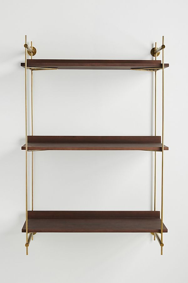 three shelves with brass handles and wooden shelves on each side, against a white wall