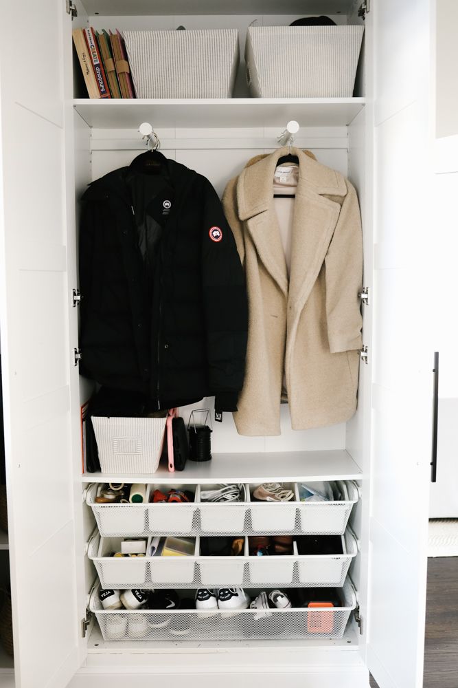 a closet with two coats and shoes on it