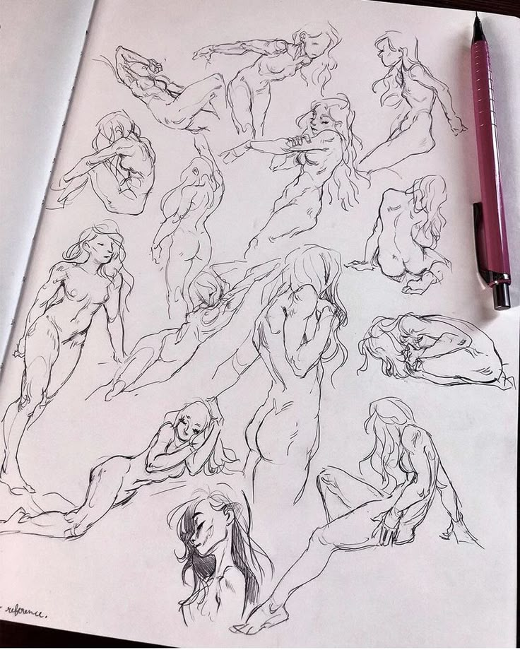 a drawing of several nude women on paper with a pen next to it and another drawing in the background