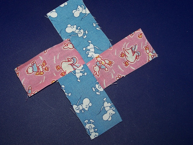 a cross made out of fabric with mickey mouse on it