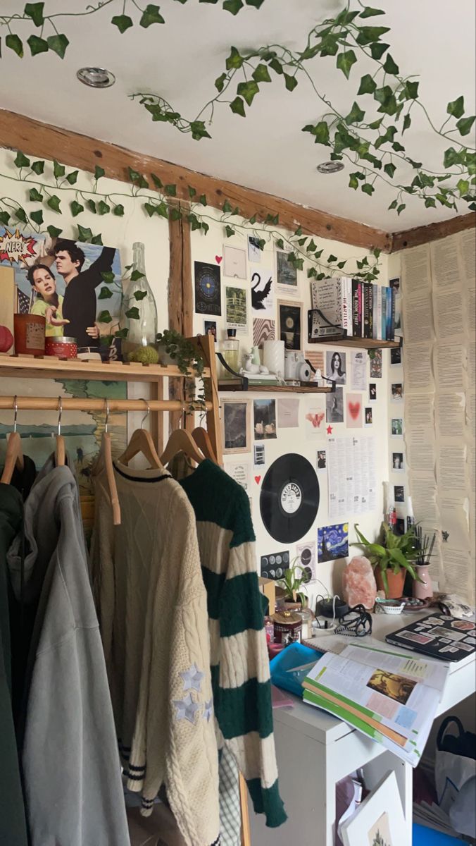 a room filled with lots of clothes hanging from the ceiling and plants growing on the wall