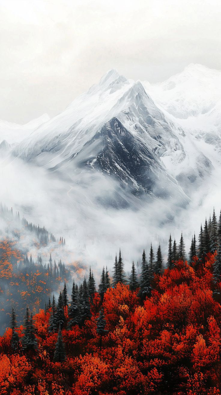 the mountains are covered in clouds and trees with orange leaves on them, as well as snow