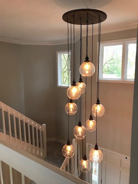 a chandelier made out of glass balls hanging from the ceiling in a house