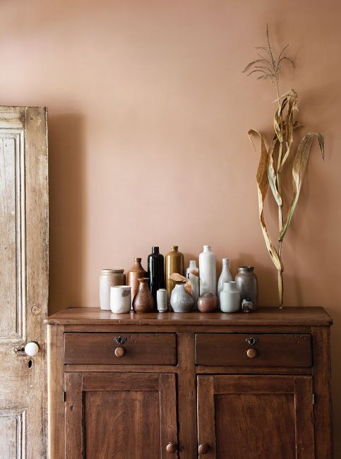 a wooden cabinet with vases and other items sitting on it's sideboard