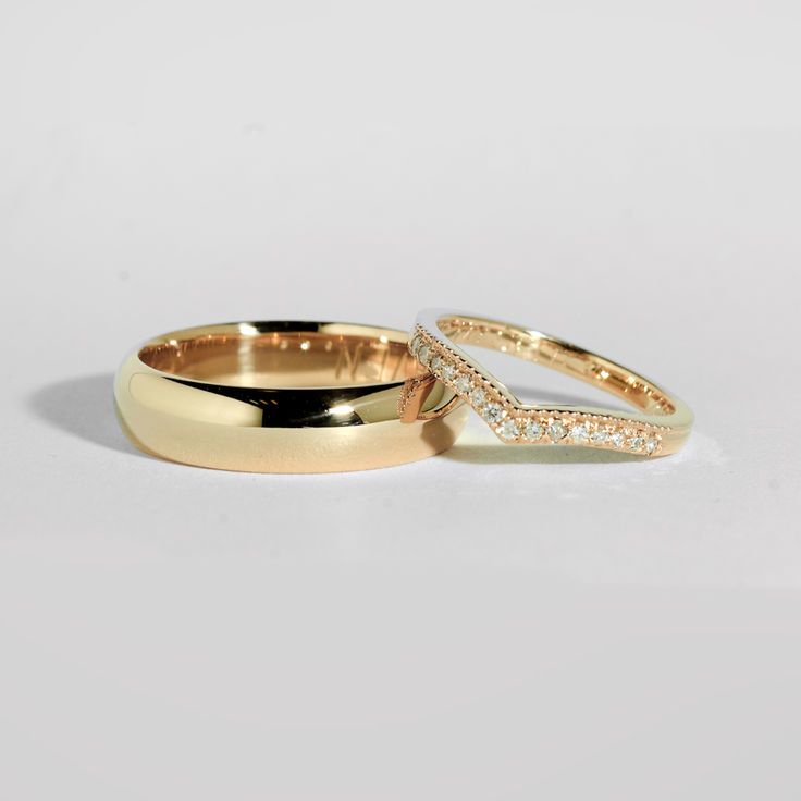 two gold wedding rings with diamonds on them