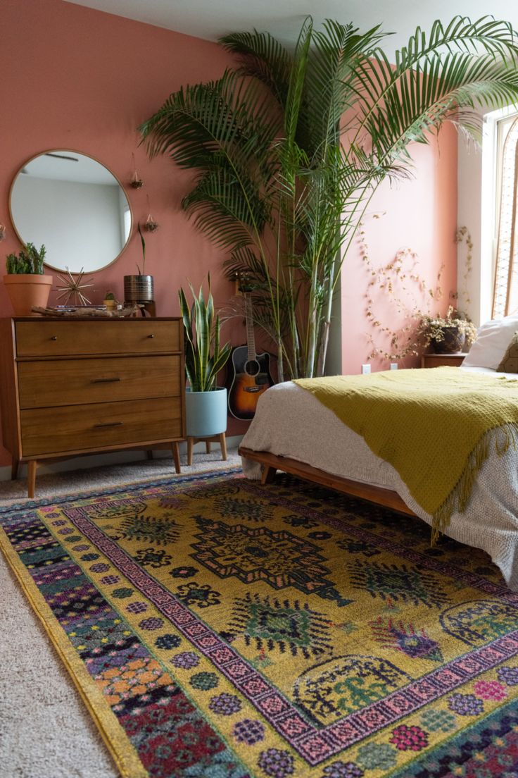 a bedroom with pink walls and a large rug on the floor next to a bed