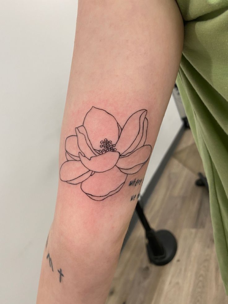 a woman's arm with a flower tattoo on it