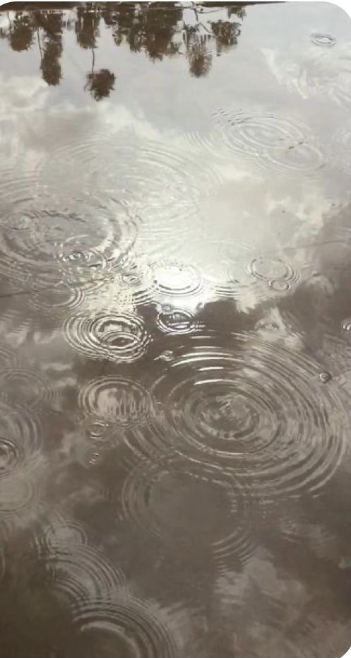 the sky is reflected in the water and it looks like rain drops are coming down