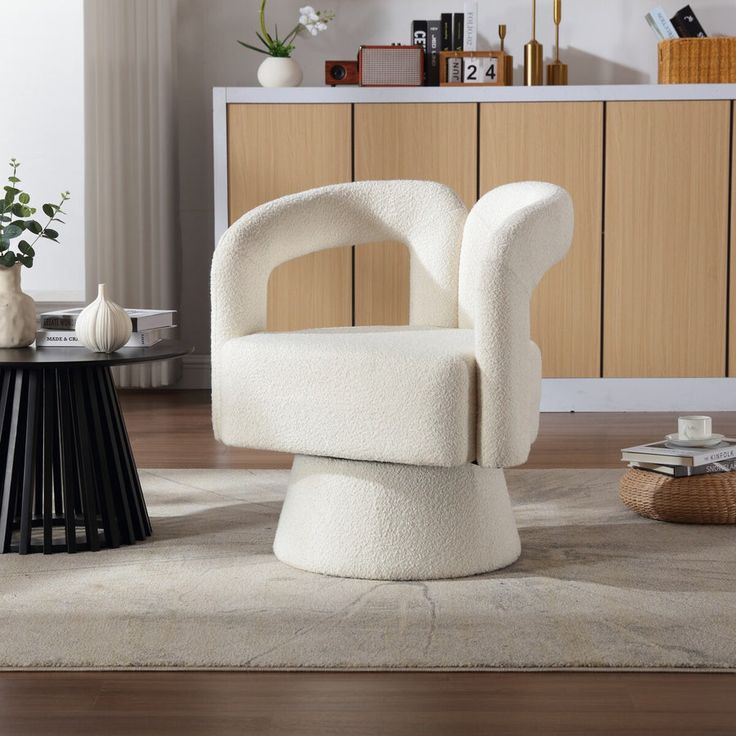 a white chair sitting on top of a rug in a living room next to a table