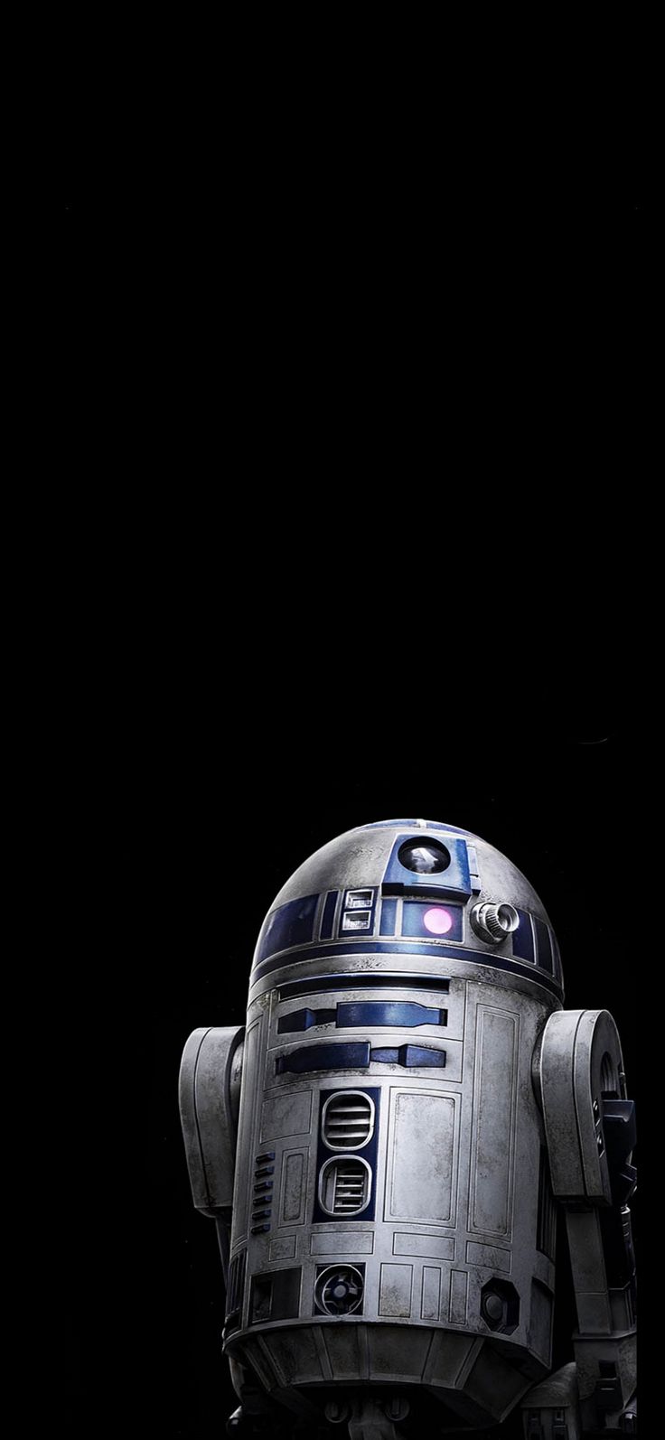 a star wars r2d2 robot is standing in the dark with its eyes closed