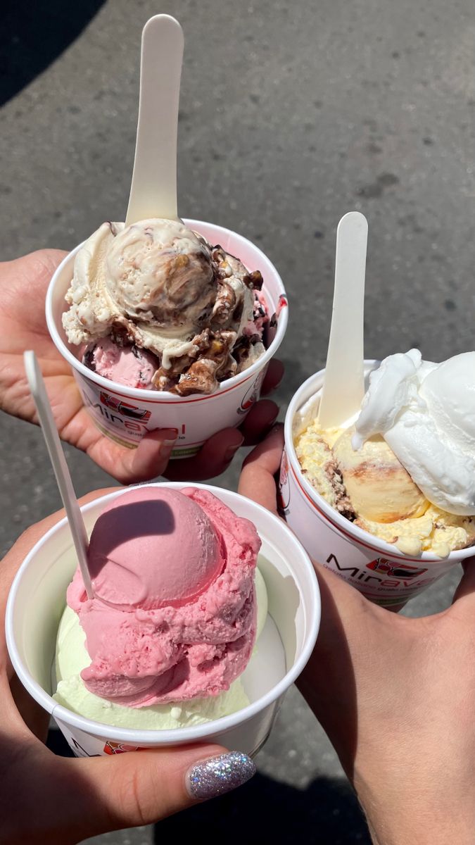 two people holding ice cream in their hands