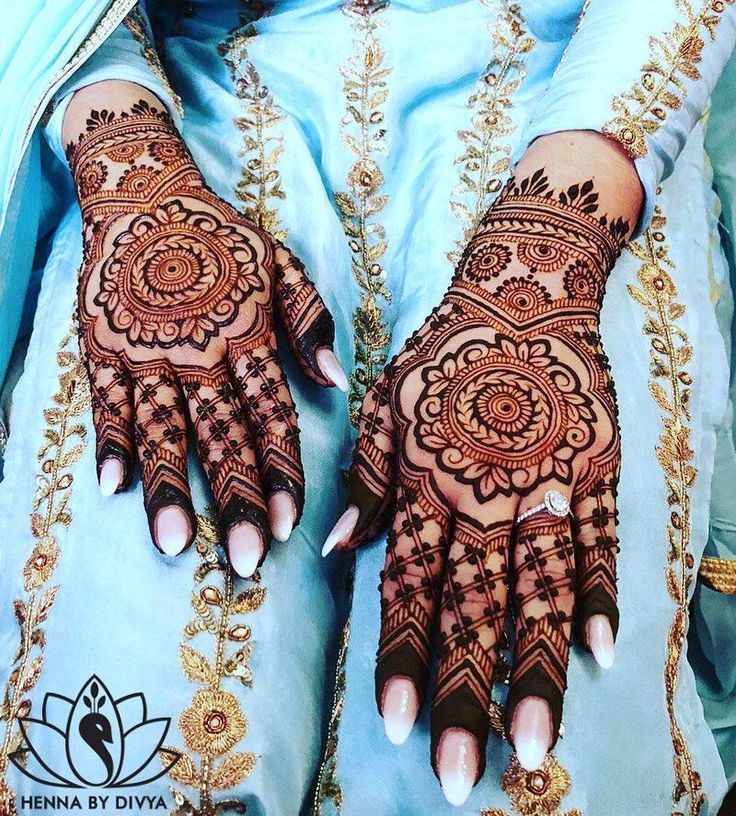 a woman's hands with henna tattoos on them