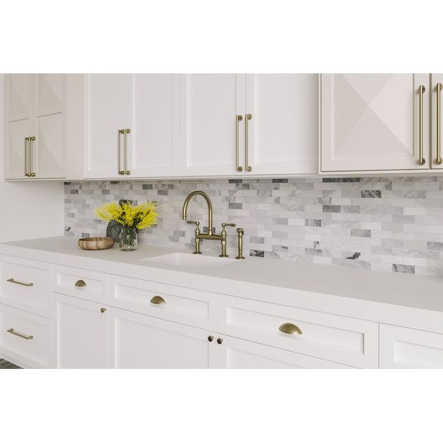 a kitchen with white cabinets and yellow flowers in a vase on the sink countertop