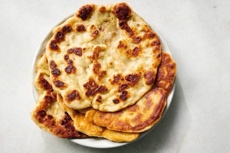 three flat breads on a white plate