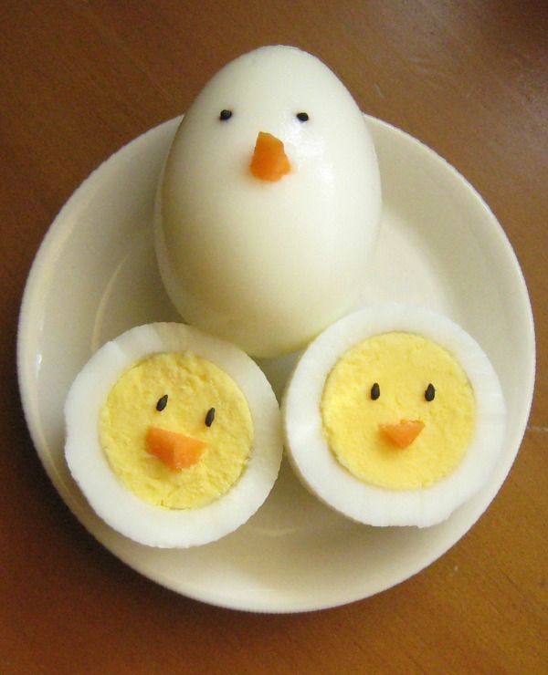 an egg with two halves cut in to look like a chicken's face on a plate