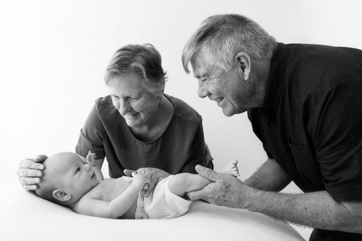 an older man and woman are looking at a baby