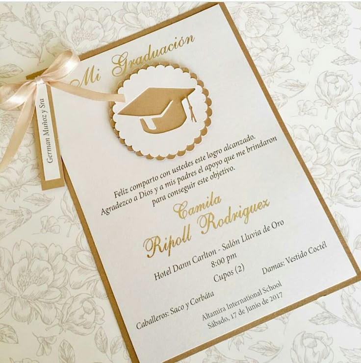 a white and gold graduation card with a brown ribbon