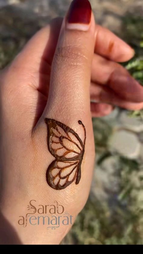 a woman's hand with a butterfly tattoo on it