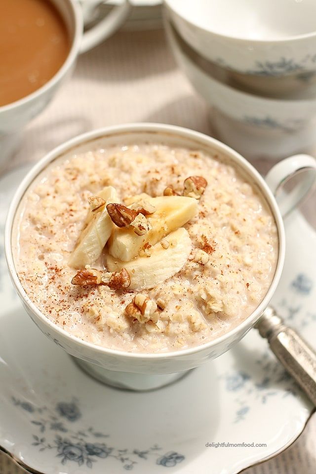 a bowl of oatmeal with bananas and walnuts in it on a plate