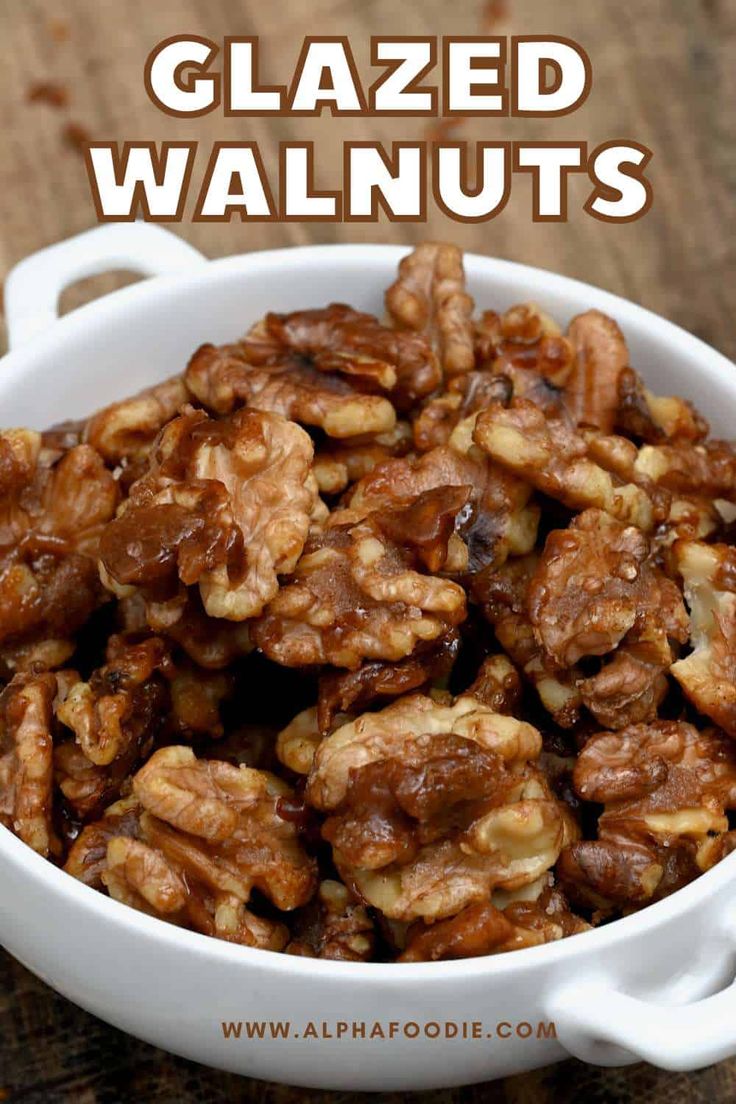 a white bowl filled with walnuts on top of a wooden table and text that reads glazed walnuts