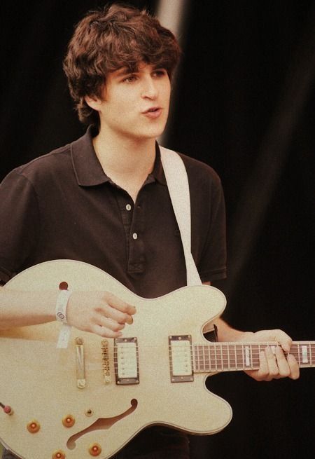 a young man playing an electric guitar on stage