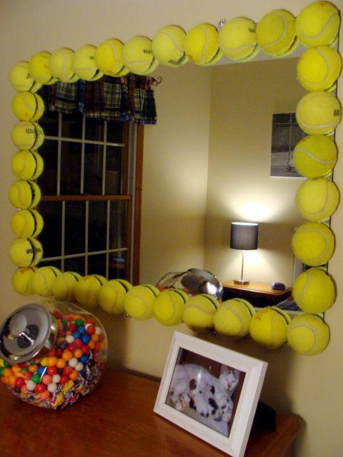 a mirror that has tennis balls on it and a bowl of candy in front of it