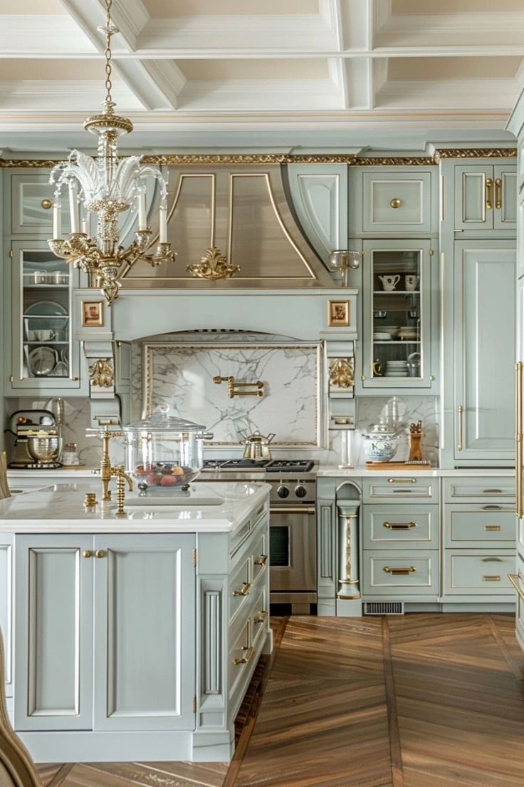 an elegant kitchen with gold accents and marble counter tops is pictured in this image, there are two chandeliers hanging from the ceiling