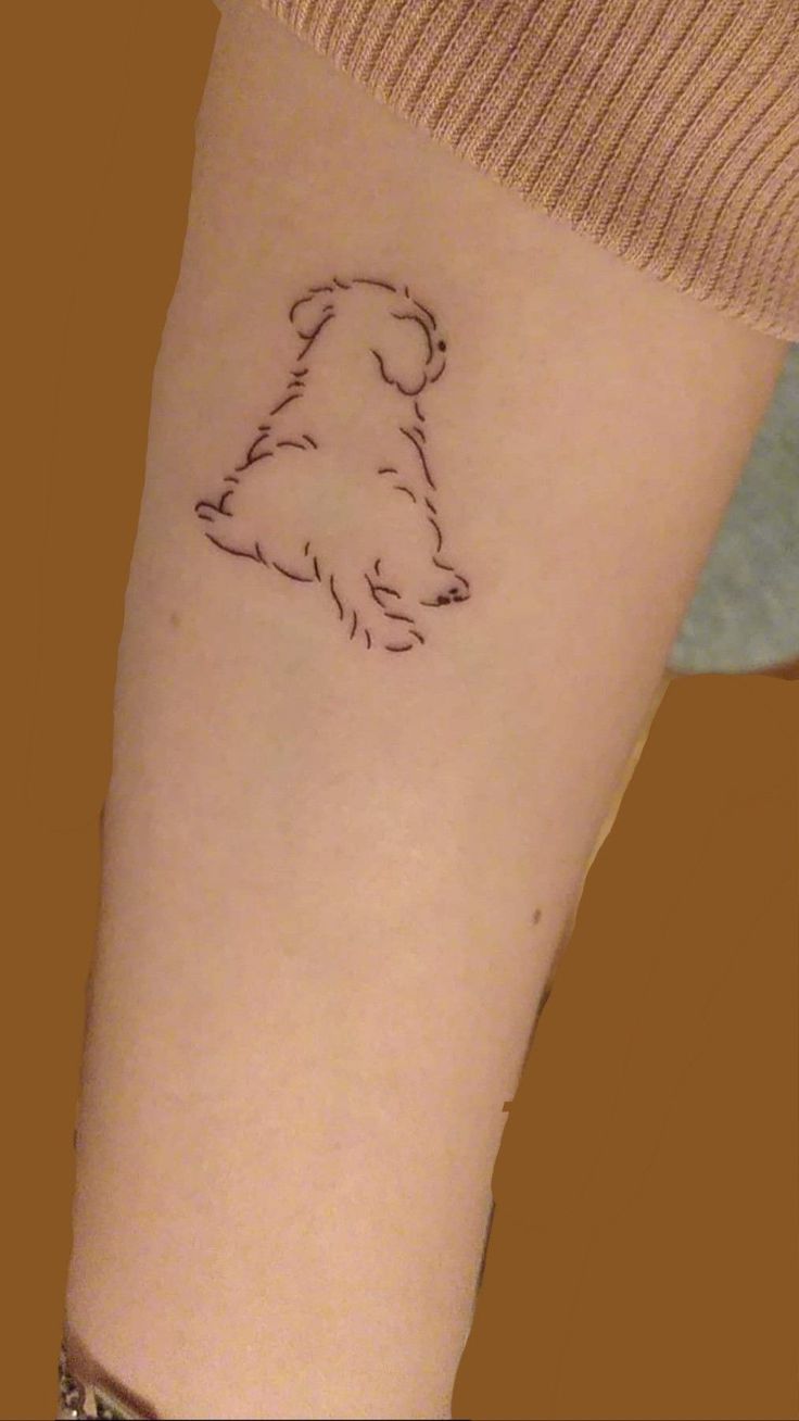 a small dog tattoo on the arm