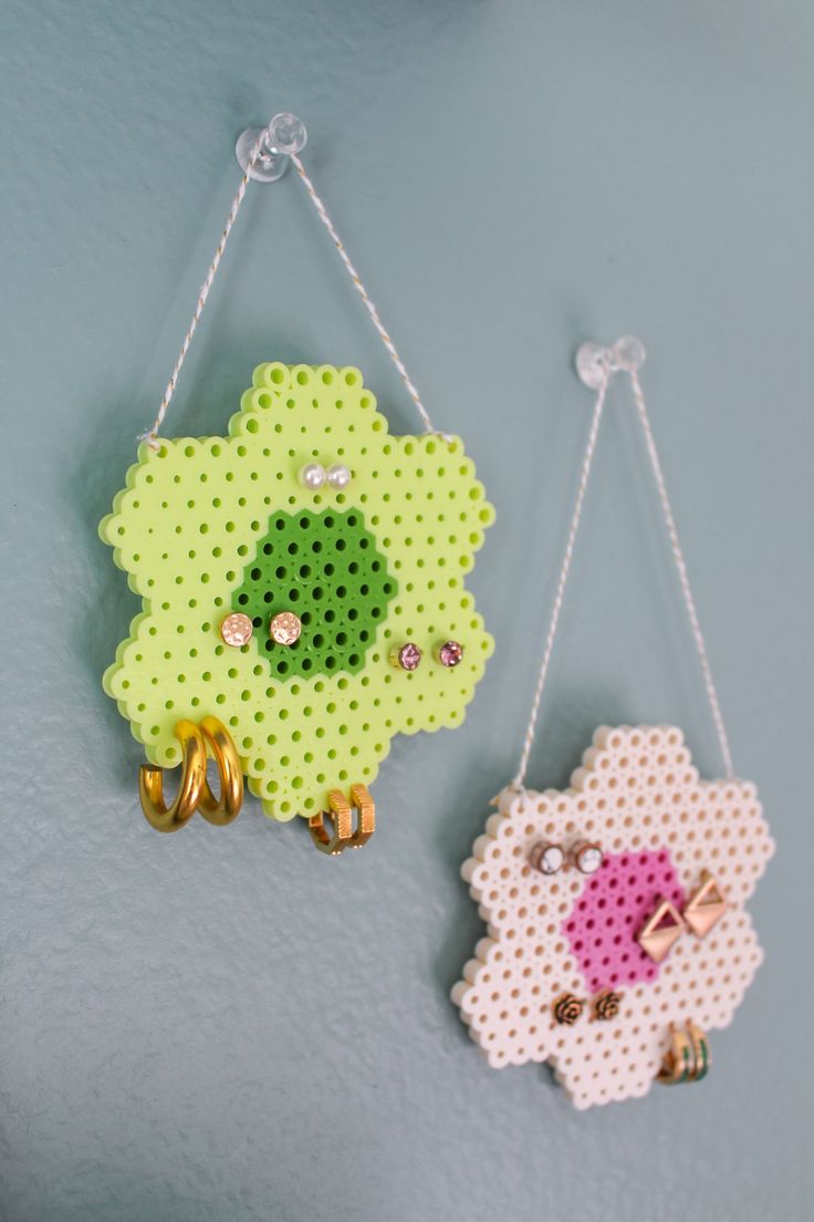 two pieces of perler bead are hanging on the wall