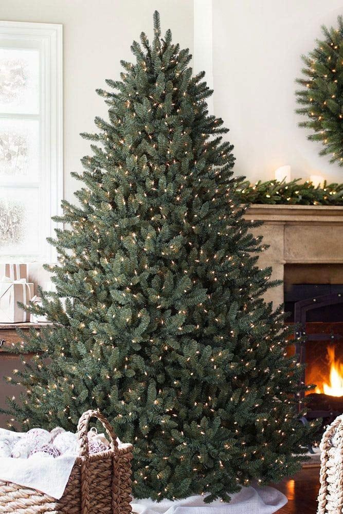 a christmas tree in a living room next to a fireplace