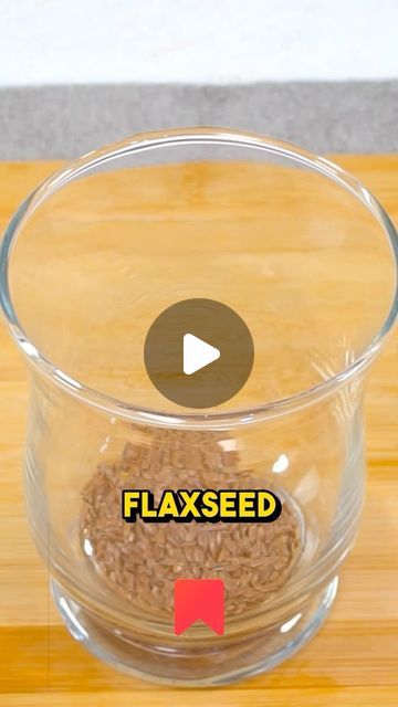 a glass bowl filled with flaxseed sitting on top of a wooden table