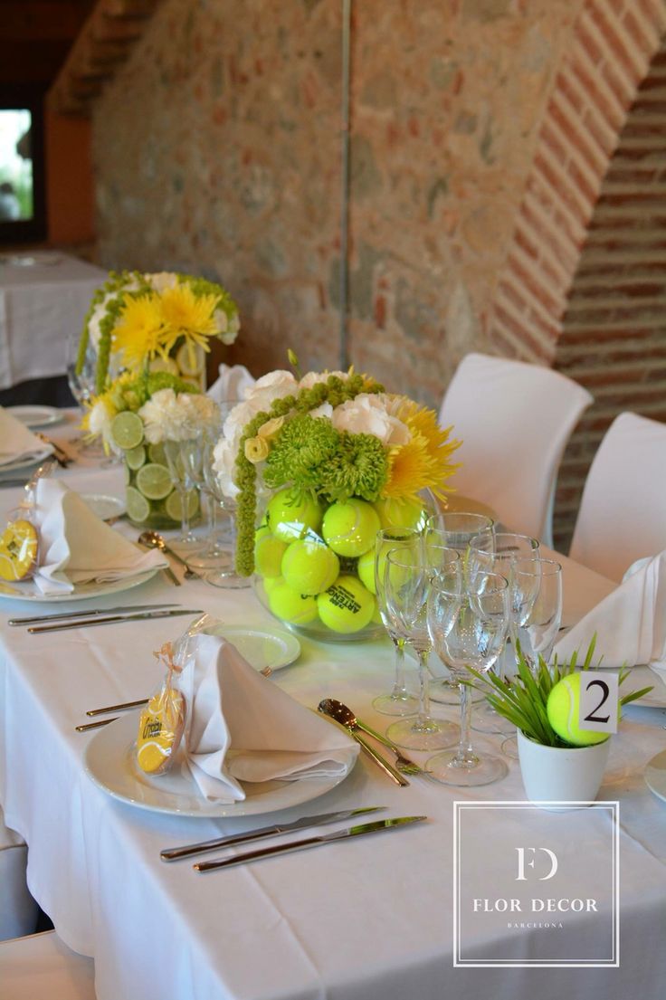 the table is set with white linens and yellow flowers